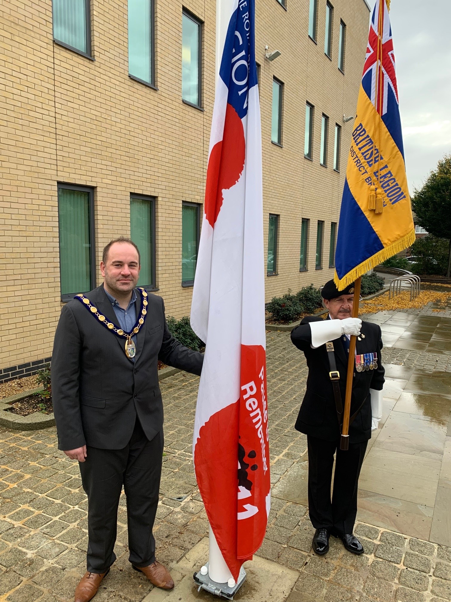 Picture of Chair, Cllr Michael Burke, raising the flag with RBL Standard Bearer, Nick Lynskey, Vice-Chairman of The Royal British Legion Huntingdon & District Branch.